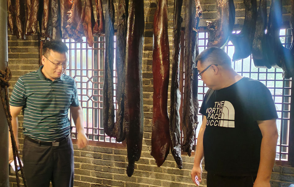 专家们在观摩湖湘肴“腊肉王”